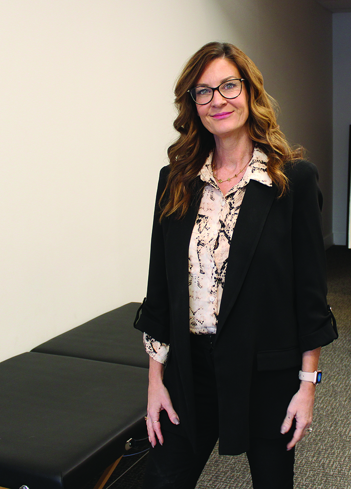 Marnie Courage stands in her clinic.