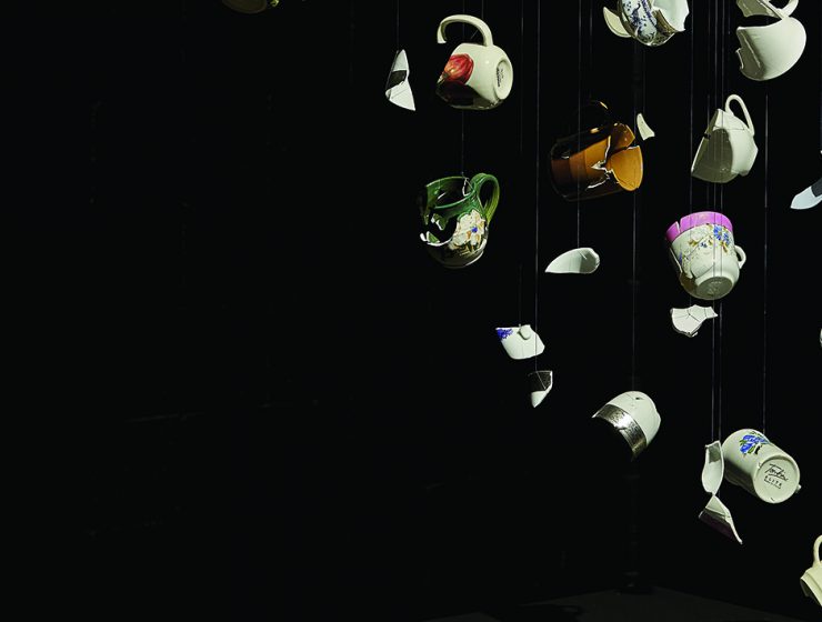 Broken teacups reassembled artistically over a black background.