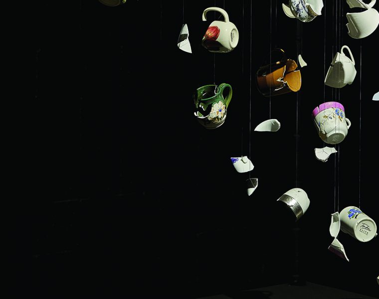 Broken teacups reassembled artistically over a black background.
