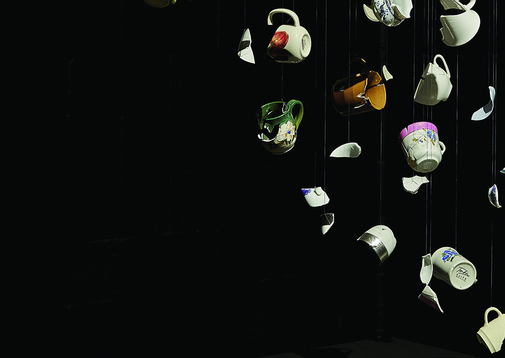 Broken teacups reassembled artistically over a black background.